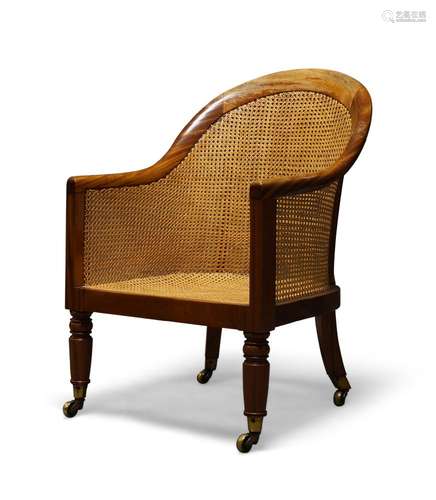 A William IV satinwood bergère armchair, with curved back and caned seat, on turned front legs