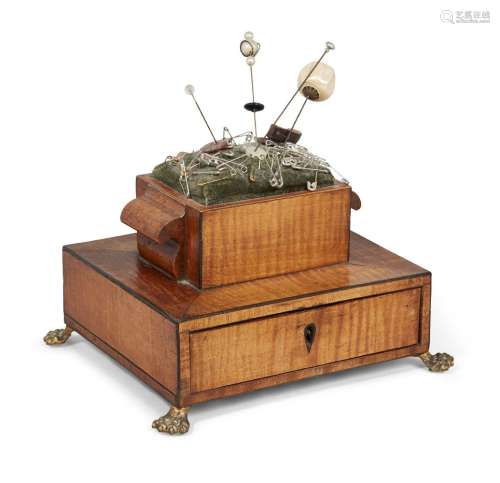 A Regency satinwood pin cushion, early 19th century, the two tier body with single long drawer to