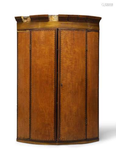 A George III satinwood and inlaid bow-fronted corner cupboard, with dentil moulded cornice, above