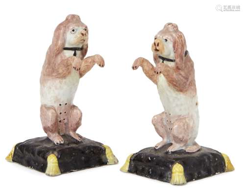 A pair 18th Century English porcelain figures, each of a begging spaniel on a square cushion base,