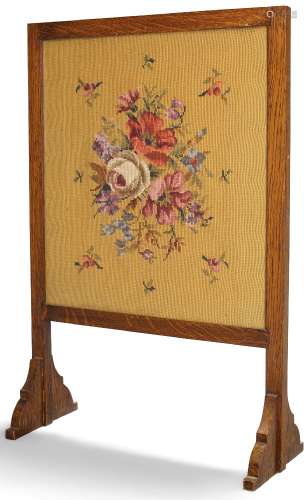 An oak and glazed firescreen, early 20th Century, with floral needlework panel set within