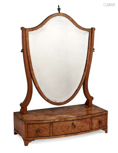 A George III satinwood swept front shield-shape toilet mirror, three drawers, on bracket feet,