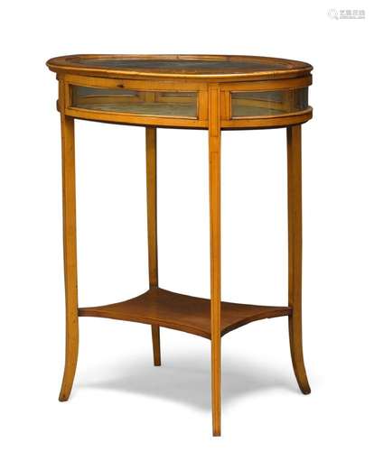 An Edwardian satinwood oval vitrine table, the crossbanded and glazed top-enclosing silk lined