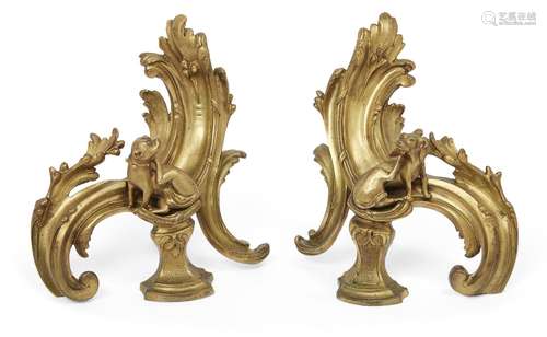 A pair of French Louis XV style ormolu chenets, 19th century, the scrolling acanthus standards