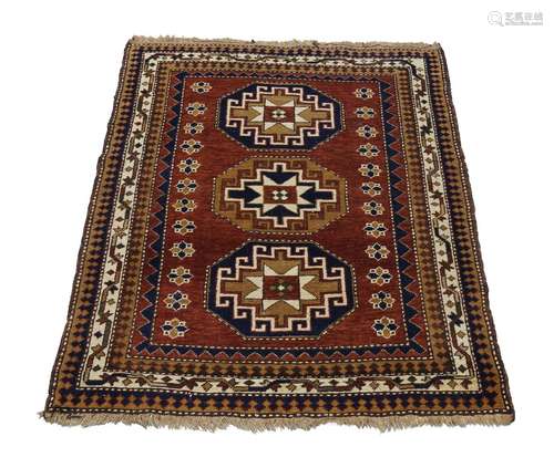 A Shirvan rug, mid to late 20th century, with three star centred octagons in a deep red field