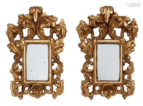 A pair of Florentine small carved giltwood mirrors, early 19th century, with foliate scroll pediment