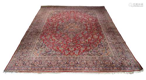 A Tabriz carpet, mid-20th century, with pole medallion in a red field with flowering stems, indigo