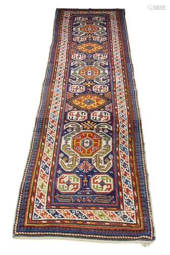 A Kazak runner, early 20th century, with octagonal medallions in a deep blue field with main ivory