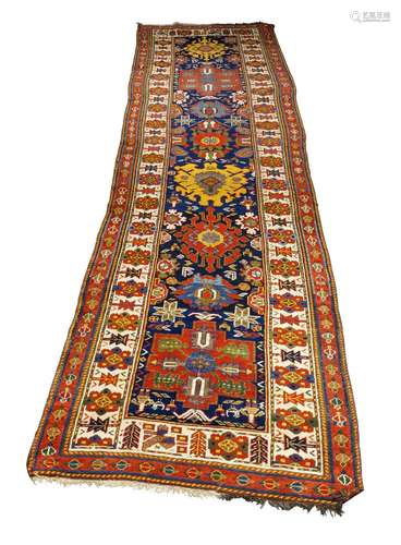 A Kazak runner, early 20th century, with eight medallions in an indigo field, the main ivory