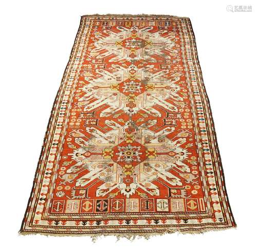 A Kazak rug, early 20th century, with three ivory double eagle medallions in a red field, with