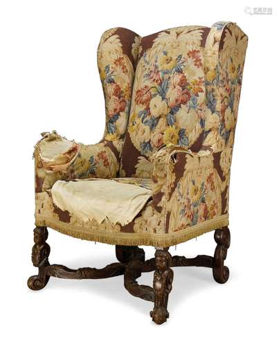 A William and Mary style wingback armchair, first half 20th century, the serpentine back with curved