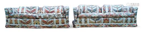 A pair of modern three seat sofas, late 20th century, with ivory and polychrome geometric pattern