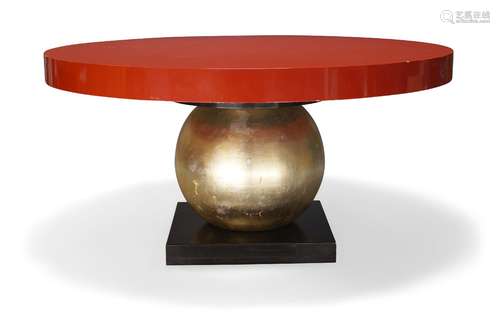 A modern circular dining table, late 20th century, with red lacquered top on gilt spherical