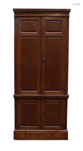 A stained pine hall cupboard, late 20th century, with moulded cornice above two panelled doors