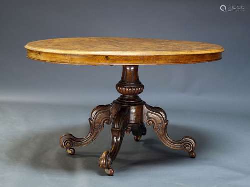 A Victorian figured walnut tilt top loo table, the oval quarter veneered top on baluster form