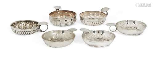 An unmarked white metal wine taster, together with a group of five silver plated examples, one