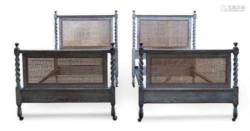 A pair of limed oak single beds, early 20th century, with caned headboard and footboard, each with