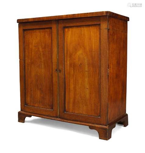 A George III mahogany cabinet, with two panelled doors enclosing four drawers and storage space,