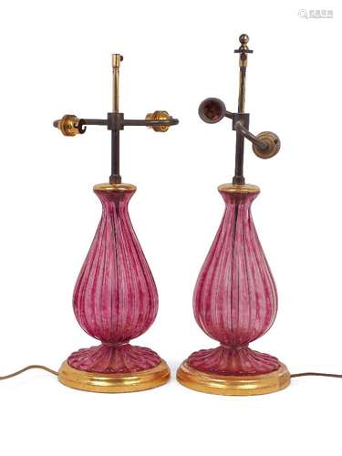 A pair of glass table lamps, 20th century, of fluted baluster form, the mottled cranberry glass