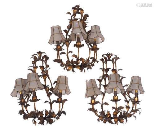 A set of three gilt metal three-branch foliate wall lights, early 20th century, 49cm high It is