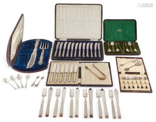 A group of various sets of cased silver flatware comprising: a set of twelve silver handled butter