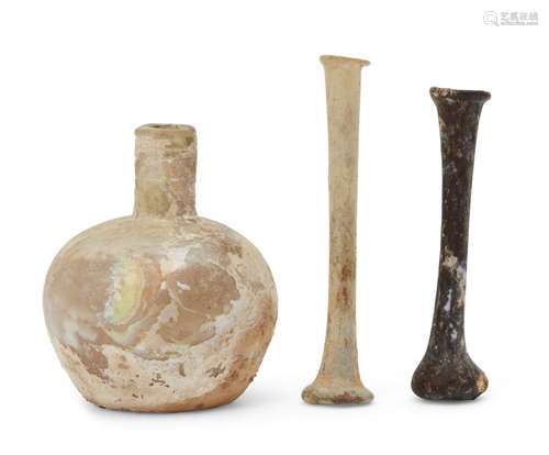 Three Roman glass vessels, 1st-5th century AD, two unguentarium and a squat clear glass vessel