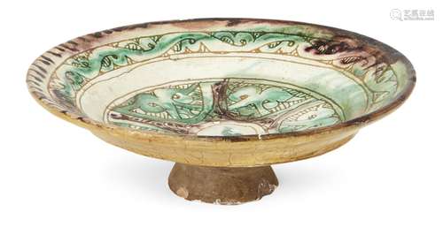 An scraffiato footed pottery dish, probably Al-Mina, 12th century, of shallow form on a raised foot,