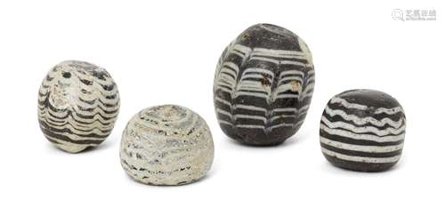 Four Ayyubid or Mamluk marvered glass gaming pieces, 12th-13th century, of spherical form, largest