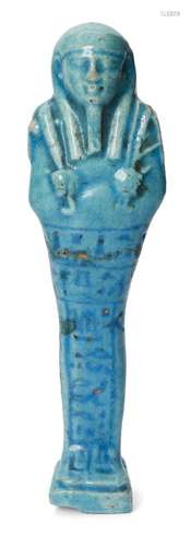 An Egyptian bright blue glazed composition shabti of typical form holding a pick and hoe with a