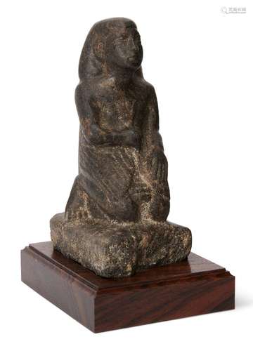 A reproduction granite Egyptian style kneeling figure wearing a shendyt kilt and bag wig, the left