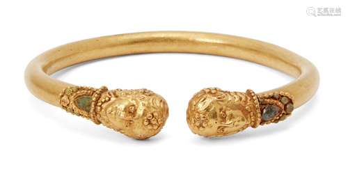 A reproduction Greek-style gold bracelet with applied terminals in the form of a female wearing a