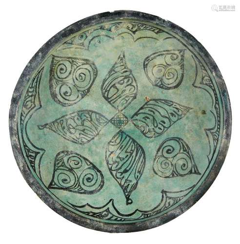 A large Kubachi ware turquoise and black glazed pottery dish, Iran, 17th century or earlier, on a