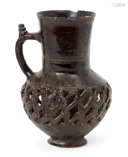 An aubergine-glazed openwork jug, Iran or Central Asia, 13th century, with short spreading foot,