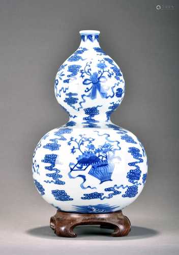 A Chinese blue and white gourd vase and wood stand