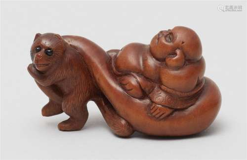 A boxwood netsuke of Hotei being pulled by a tanuki. 19th ce...