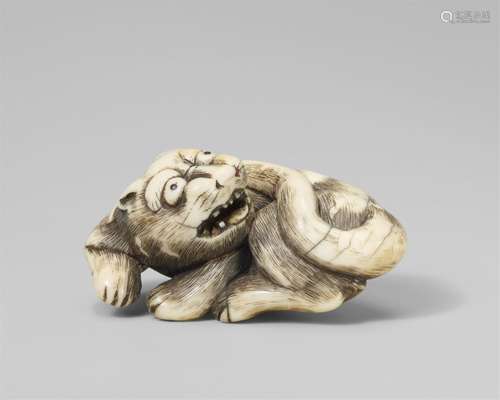 A Kyoto school ivory netsuke of a recumbent tiger. Late 18th...