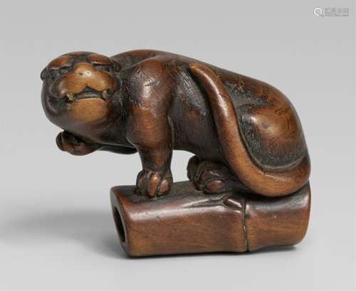 A boxwood netsuke of a tiger on bamboo. First half 19th cent...