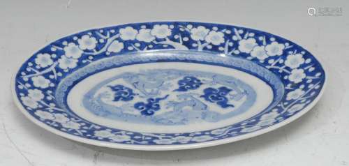 A Chinese oval meat plate, decorated in underglaze tones of ...