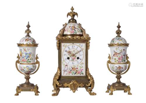 A French gilt brass and painted porcelain mantel clock garni...