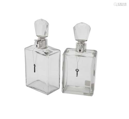 A pair of silver mounted lockable glass decanters by Hukin &...