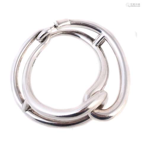 A silver coloured hinged bangle by Hermès