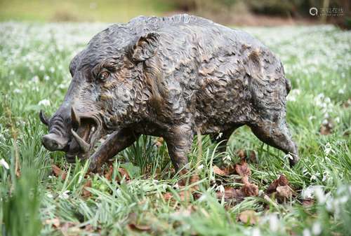 A patinated bronze model of a walking boar