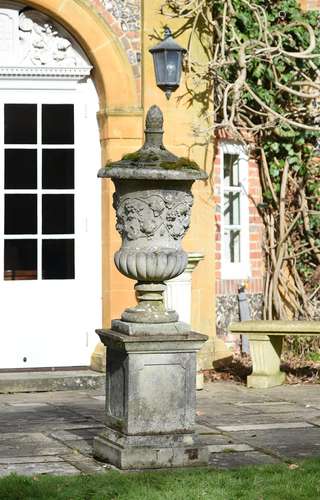 A large stone composition urn on plinth