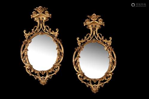 A pair of giltwood oval wall mirrors, in 18th century style,...