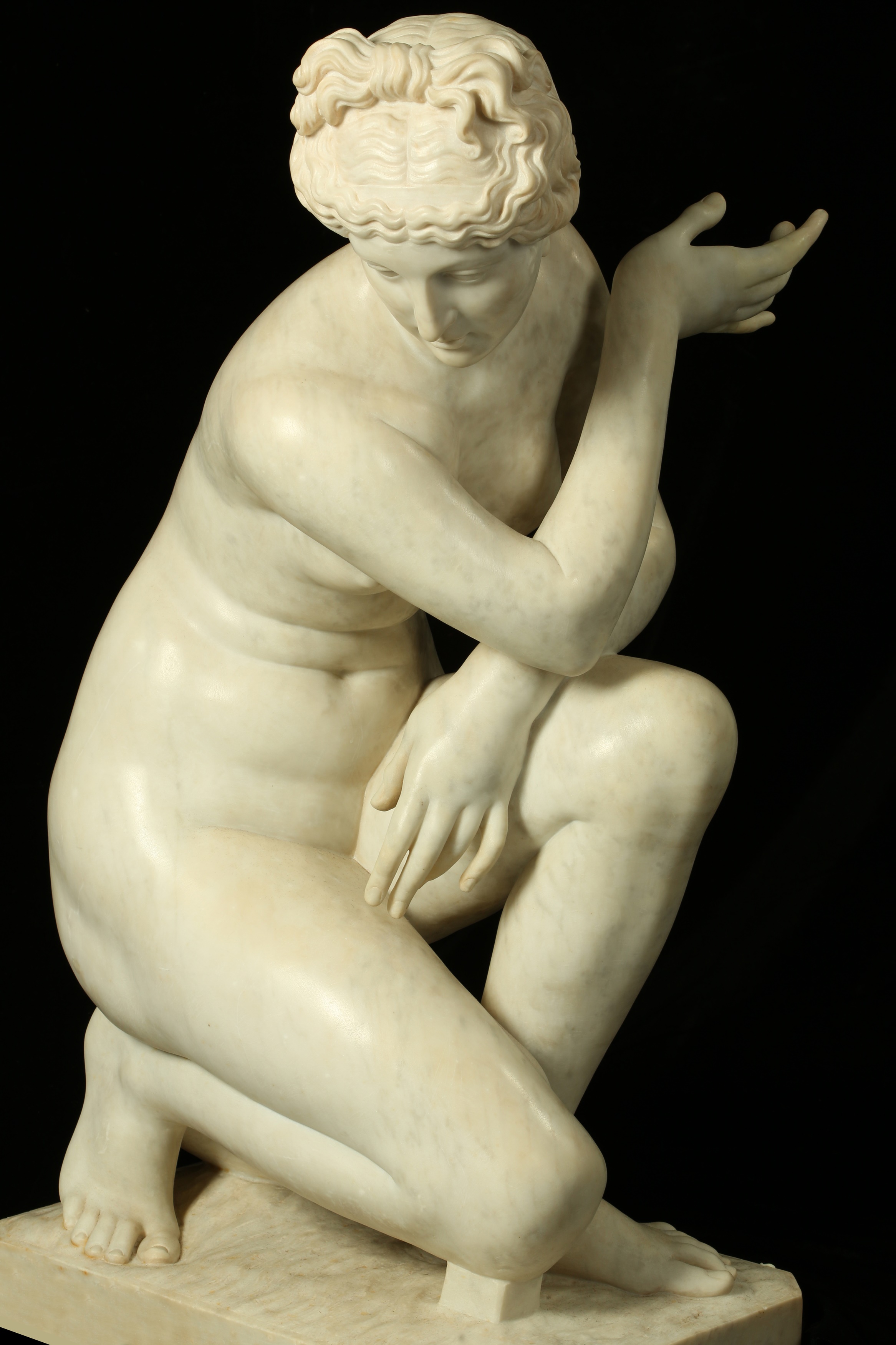 A LARGE CARVED MARBLE FIGURE OF THE CROUCHING VENUS, AFTER T 