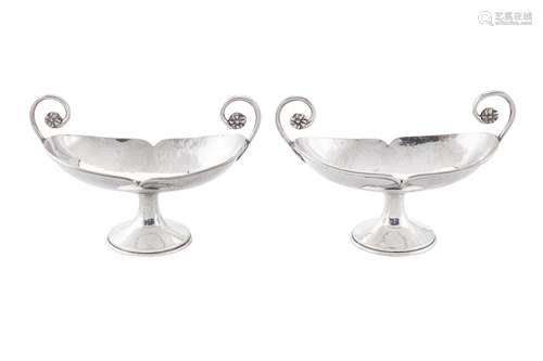 A pair of George V 'Arts and Crafts' sterling silver twin ha...