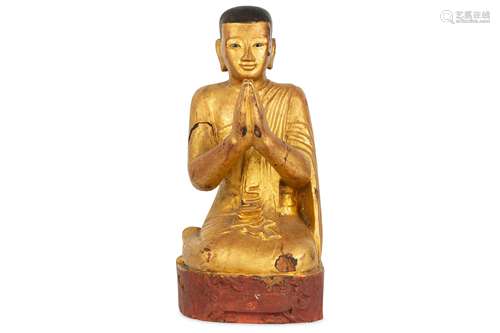 A GILT-WOOD FIGURE OF A PRAYING MONK.