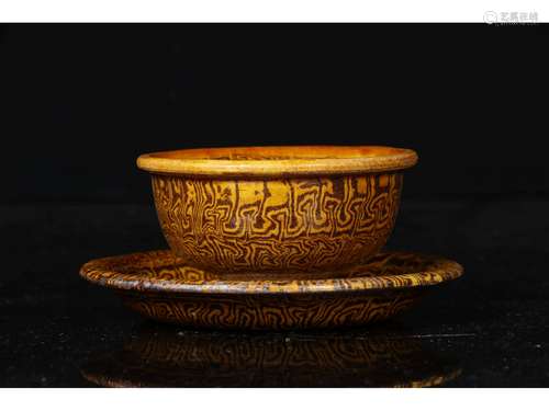 A MARBLE-GLAZED TEA CUP AND STAND