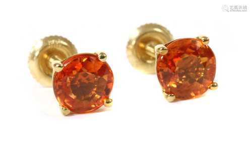 A pair of gold single stone orange sapphire stud earrings,