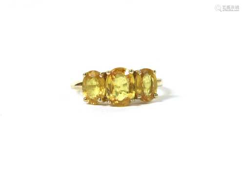 A gold three stone yellow sapphire ring,